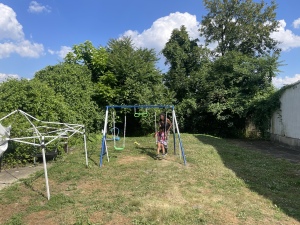 Trina pushing her granddaughter on a slide next to her property. (GIH | Dashiell Allen)